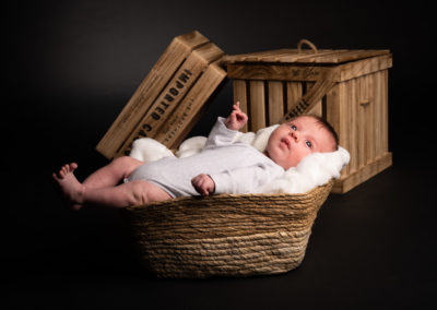 Enfant dans une panière lors d'une séance photo pro