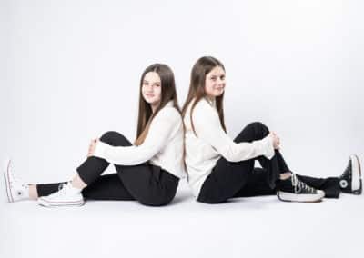 deux femmes en shooting avec haut blanc et pantalon noir sur fond blanc