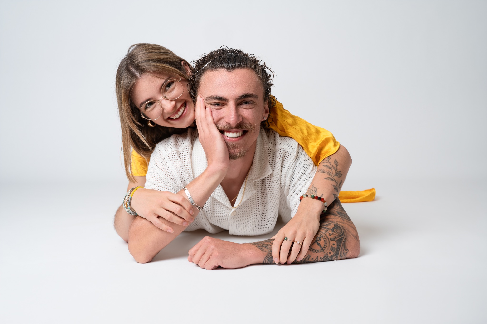 Un père et sa fille souriant ensemble, allongés au studio